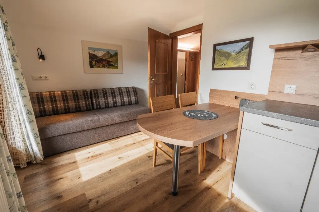 Wohnraum mit Couch und Essplatz in Wohnung 6