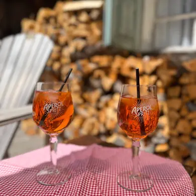 Zwei Aperol Spritz Gläser auf einer sonnigen Terrasse