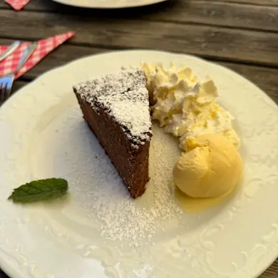 Ein Stück hausgemachter Schokoladenkuchen mit Schlagobers und Eis